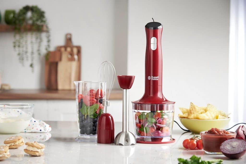 Mixeur plongeur avec des accessoires et des récipients contenant des légumes